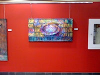 a red wall with paintings hanging on it