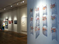 an art gallery with a lot of art hanging on the wall