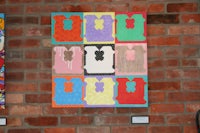 a piece of art hanging on a brick wall