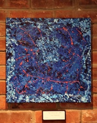 a blue and red painting on a brick wall