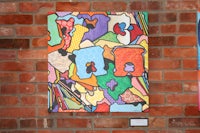 a piece of art hanging on a brick wall