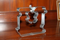 a metal cookie cutter sitting on a wooden table