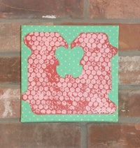 a piece of art with polka dots on a brick wall
